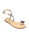 Beige sandal with decorative straps on a white background